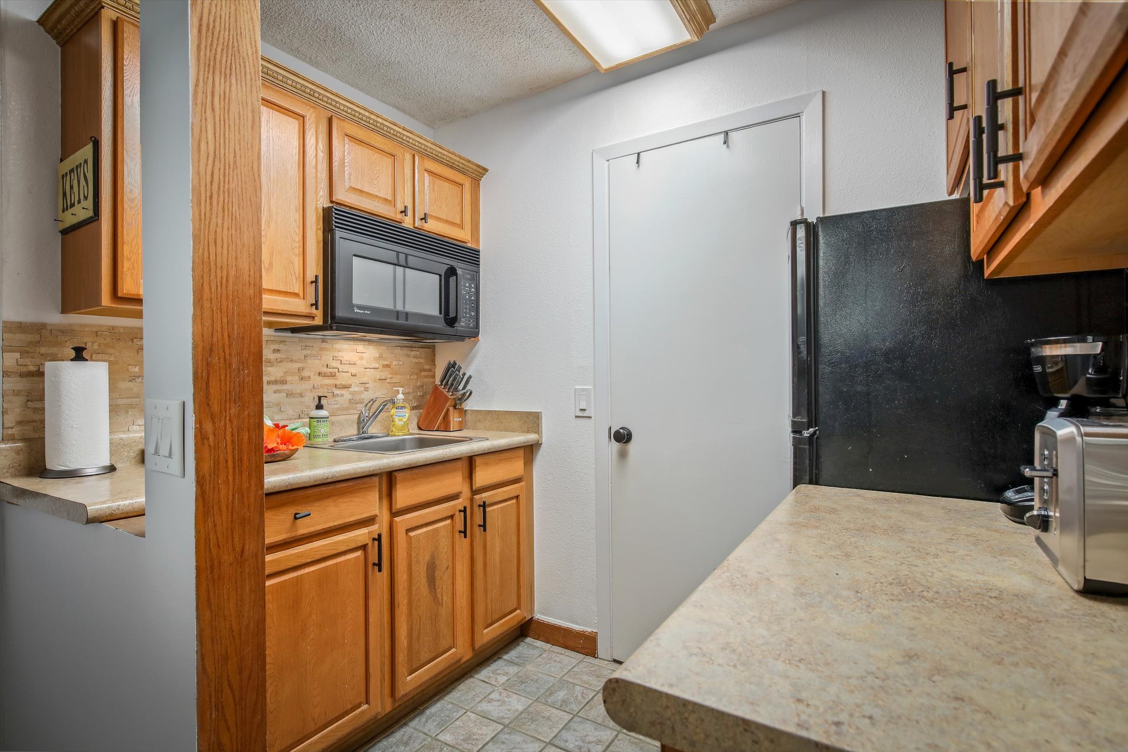 75-5776 Kuakini Highway, Unit 123 Kailua-Kona, HI 96740 - Photo 11 of 26 a kitchen with stainless steel appliances granite countertop a refrigerator and a stove top oven