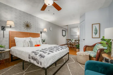 a bedroom with a bed a couch and potted plant