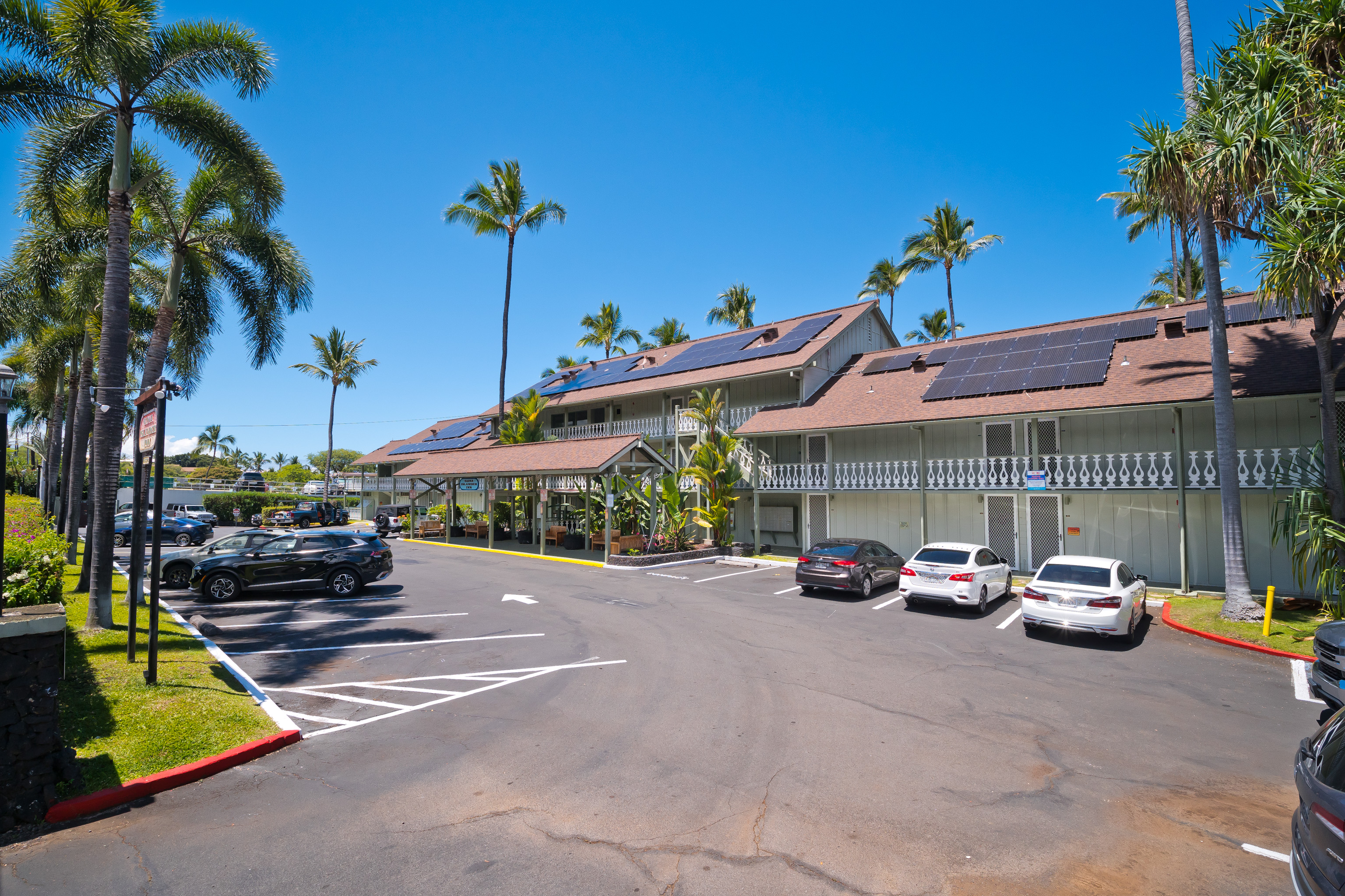 75-5776 Kuakini Highway, Unit 123 Kailua-Kona, HI 96740 - Photo 25 of 26 a car parked in front of a building with cars parked