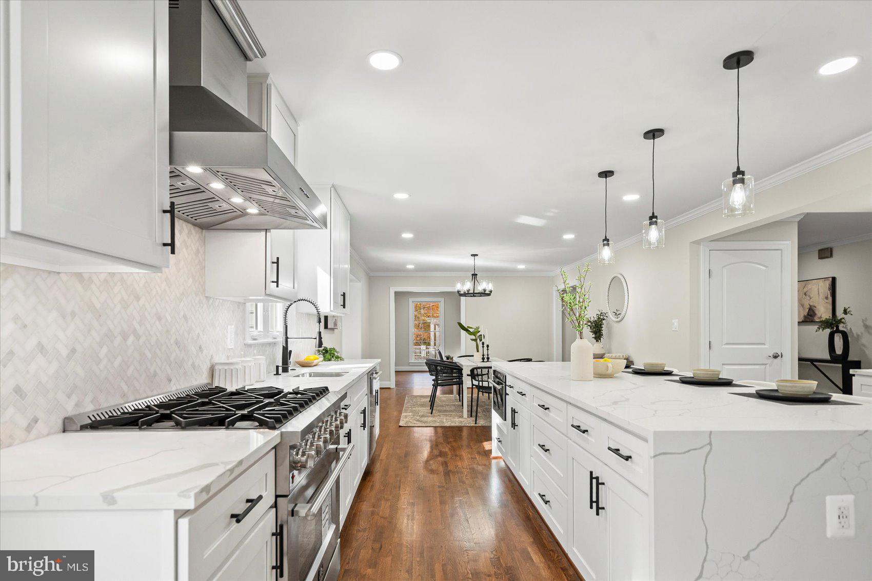 7604 Hackamore Drive Potomac, MD 20854 - Photo 27 of 81 a large kitchen with kitchen island a stove a sink a center island and wooden floor