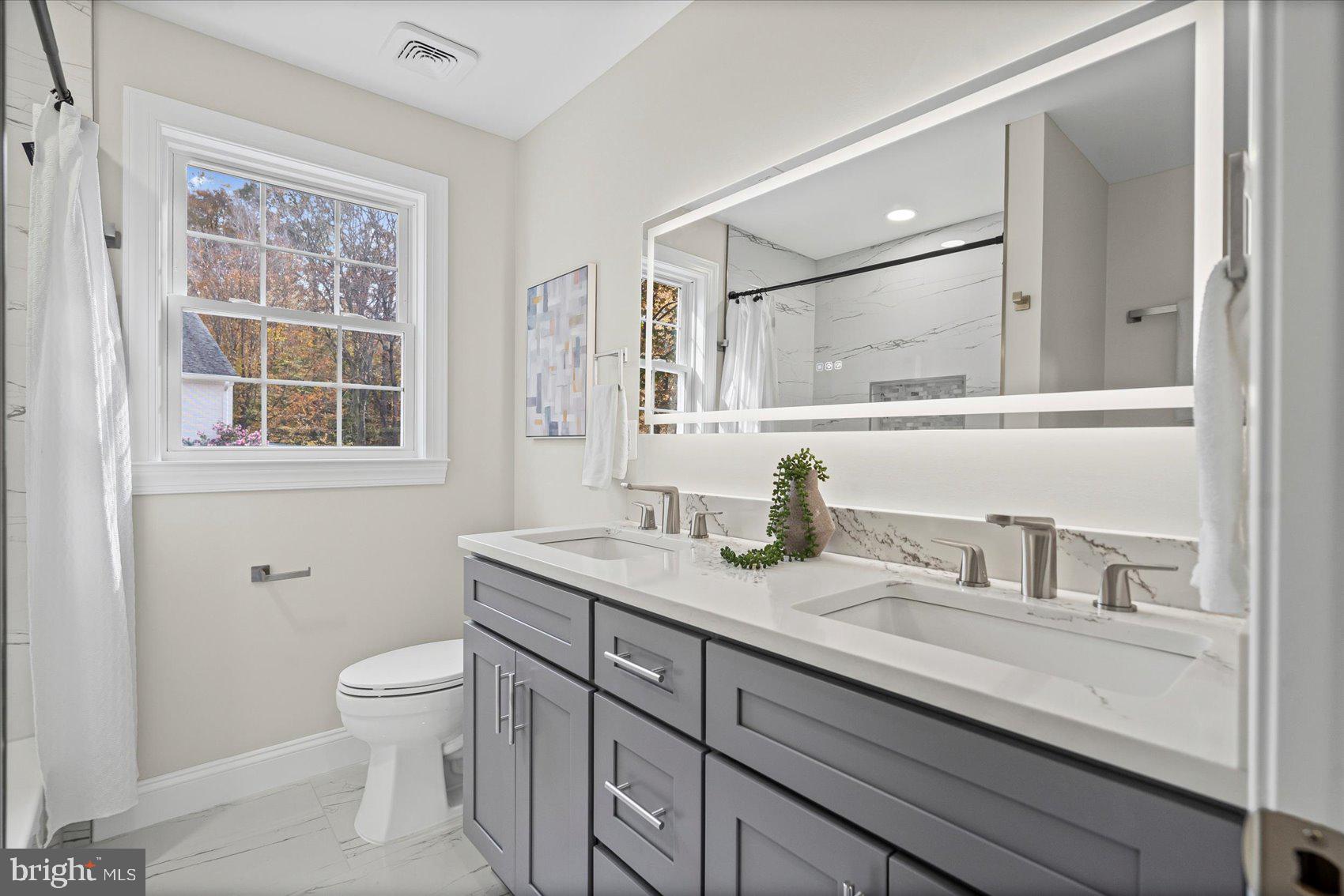 7604 Hackamore Drive Potomac, MD 20854 - Photo 58 of 81 a bathroom with a granite countertop sink a toilet and a mirror