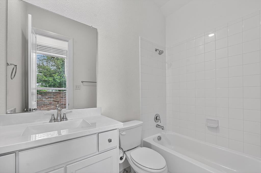 1153 Queensdown Way Forney, TX 75126 - Photo 13 of 26 White bathroom featuring a single vanity with integrated sink, chrome faucet, and a large wall-mounted mirror