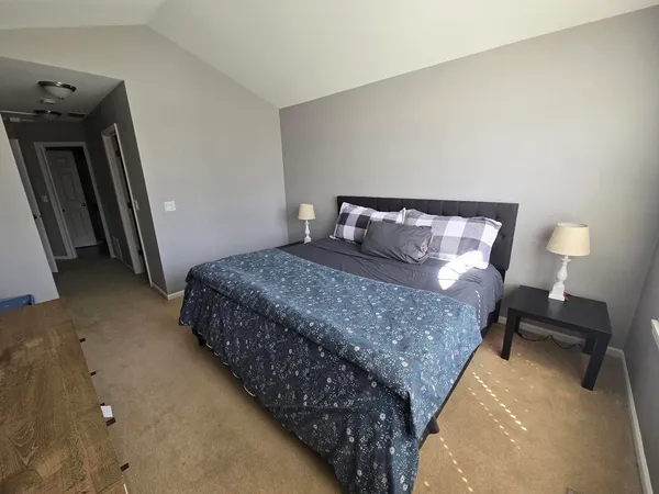 a bedroom with a bed and a lamp on table