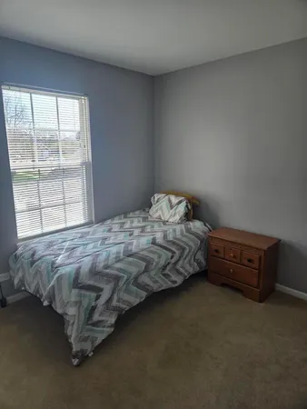 a bedroom with bed and window