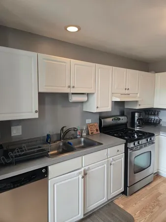 a kitchen with white cabinets and white appliances