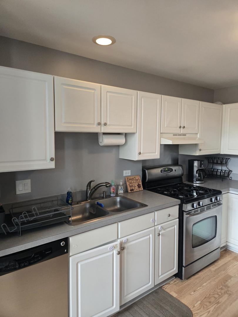 1328 Shawford Way Elgin, IL 60120 - Photo 3 of 19 a kitchen with white cabinets and white appliances