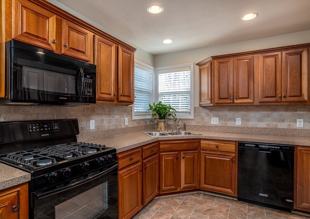 3 Michael Drive, Unit 3 Thorndike, MA 01079 - Photo 11 of 40 a kitchen with stainless steel appliances granite countertop wooden cabinets and a stove top oven