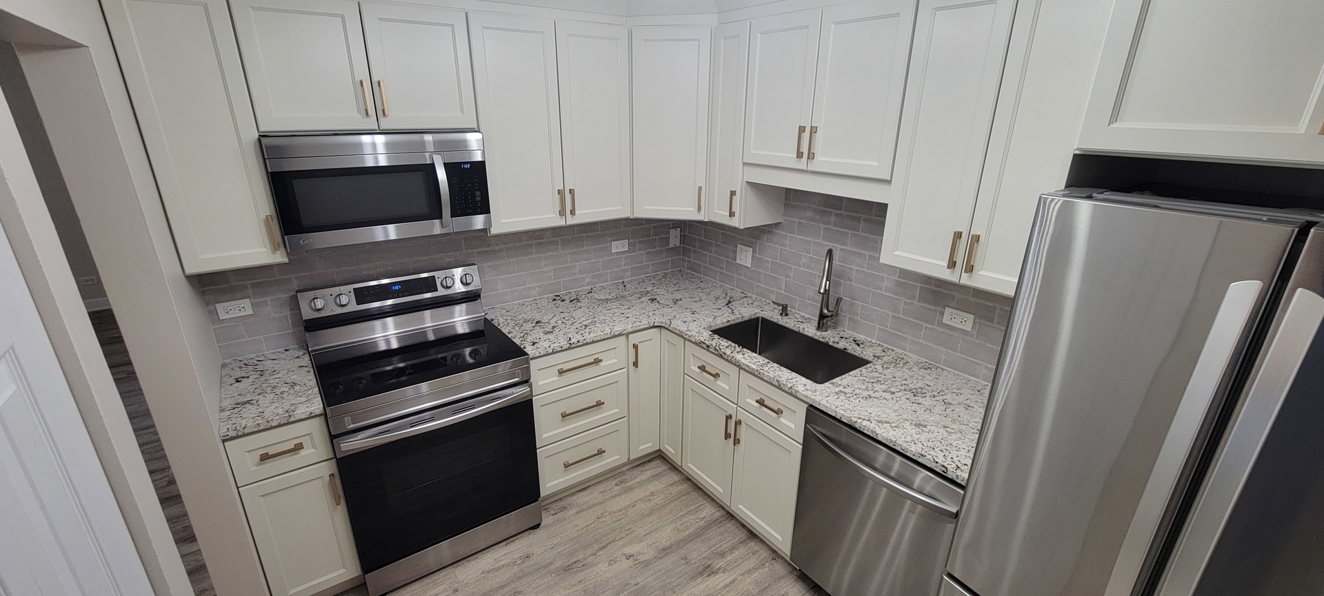 675 Grove Terrace, Unit 311 Elk Grove Village, IL 60007 - Photo 9 of 14 a kitchen with granite countertop white cabinets and stainless steel appliances