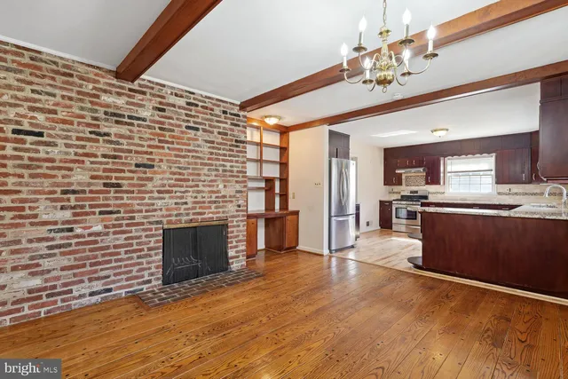 a view of kitchen with kitchen island wooden floor and fireplace
