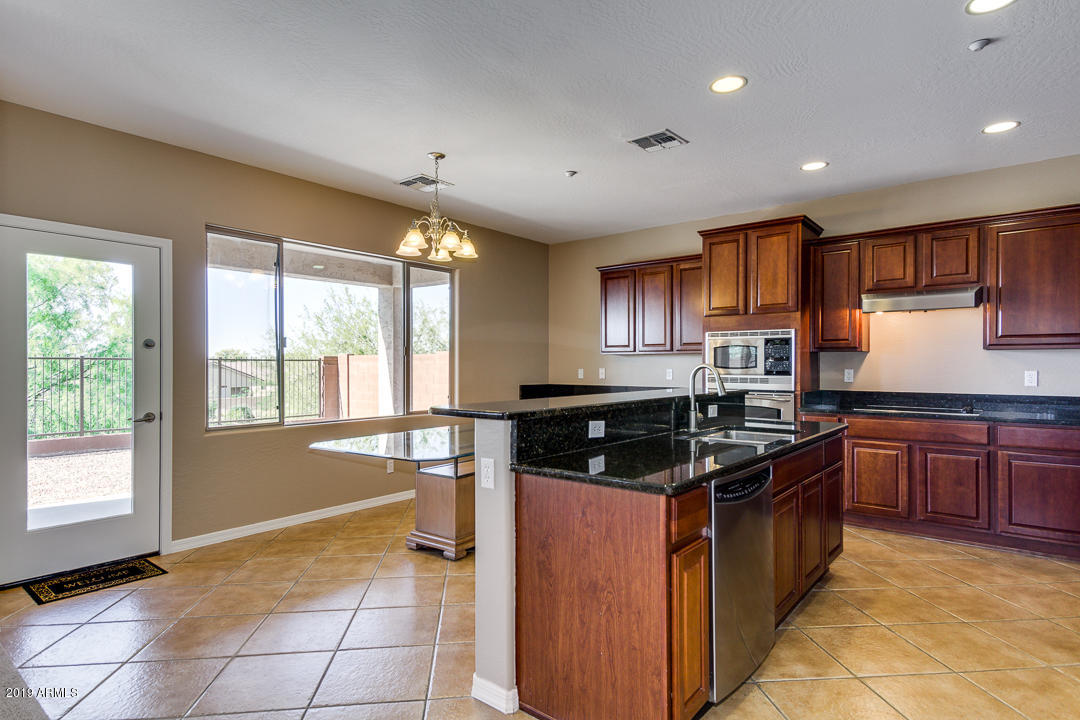 9121 West Plum Road Peoria, AZ 85383 - Photo 18 of 69 a kitchen with stainless steel appliances granite countertop a stove a sink and a refrigerator