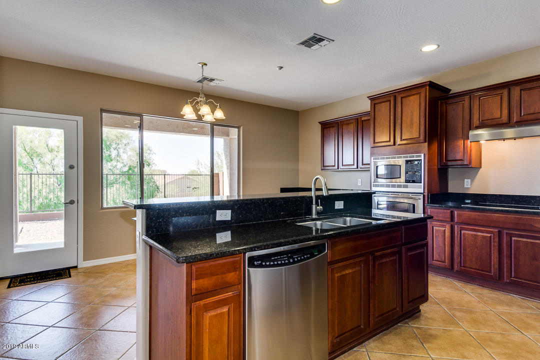9121 West Plum Road Peoria, AZ 85383 - Photo 24 of 69 a kitchen with granite countertop a sink and a stove