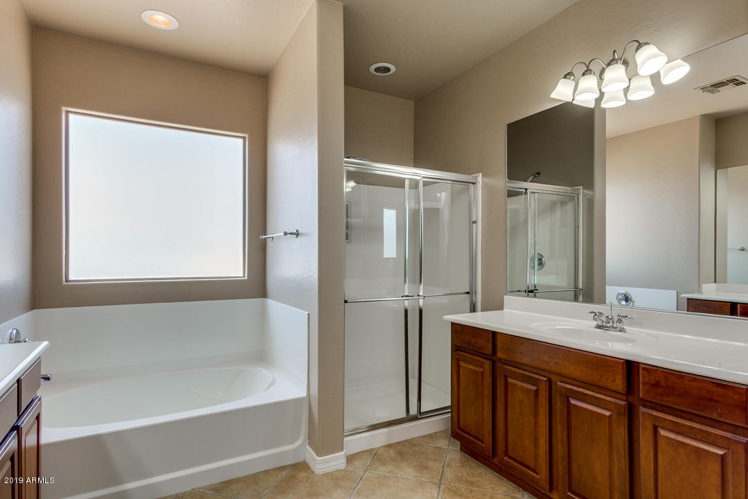 9121 West Plum Road Peoria, AZ 85383 - Photo 42 of 69 a bathroom with a tub sink shower and mirror