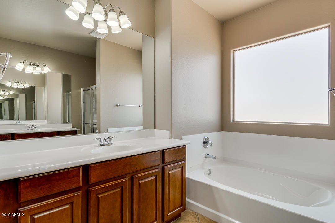 9121 West Plum Road Peoria, AZ 85383 - Photo 44 of 69 a bathroom with a tub a sink and a large mirror