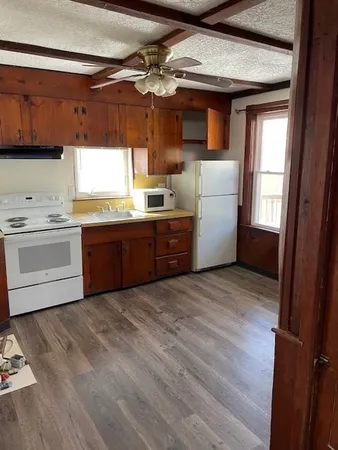 a kitchen with granite countertop a sink cabinets stainless steel appliances and a window