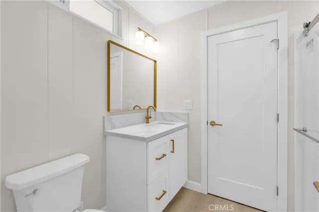 a bathroom with a toilet a sink a vanity and mirror