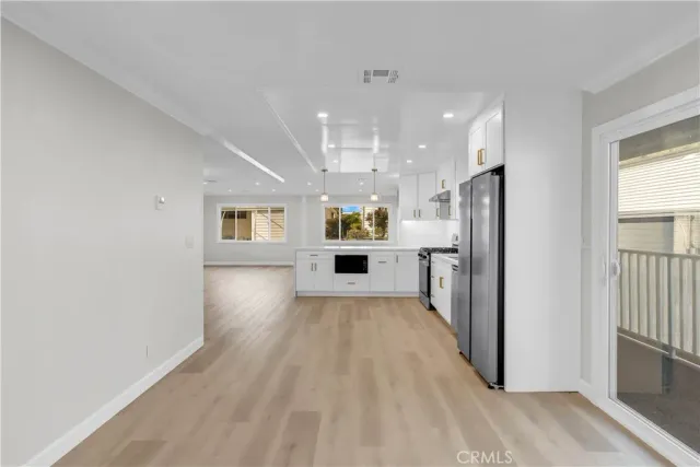 a view of a refrigerator in kitchen and wooden floor