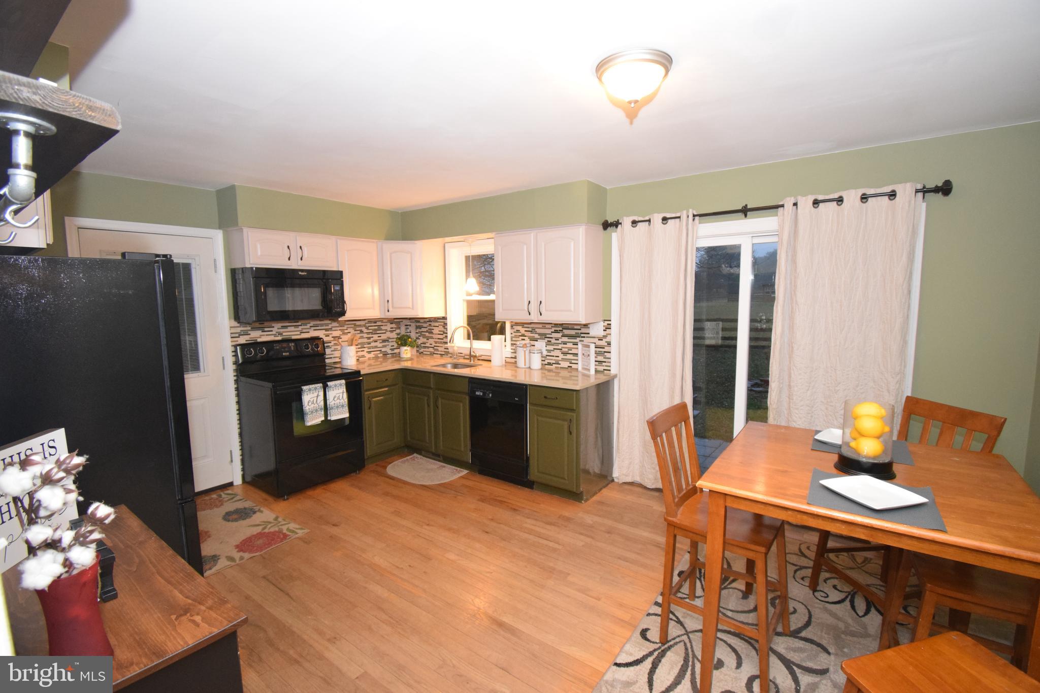 87 Half Mile Turn Rising Sun, MD 21911 - Photo 16 of 31 a kitchen with stainless steel appliances a sink a stove a refrigerator cabinets and a dining table