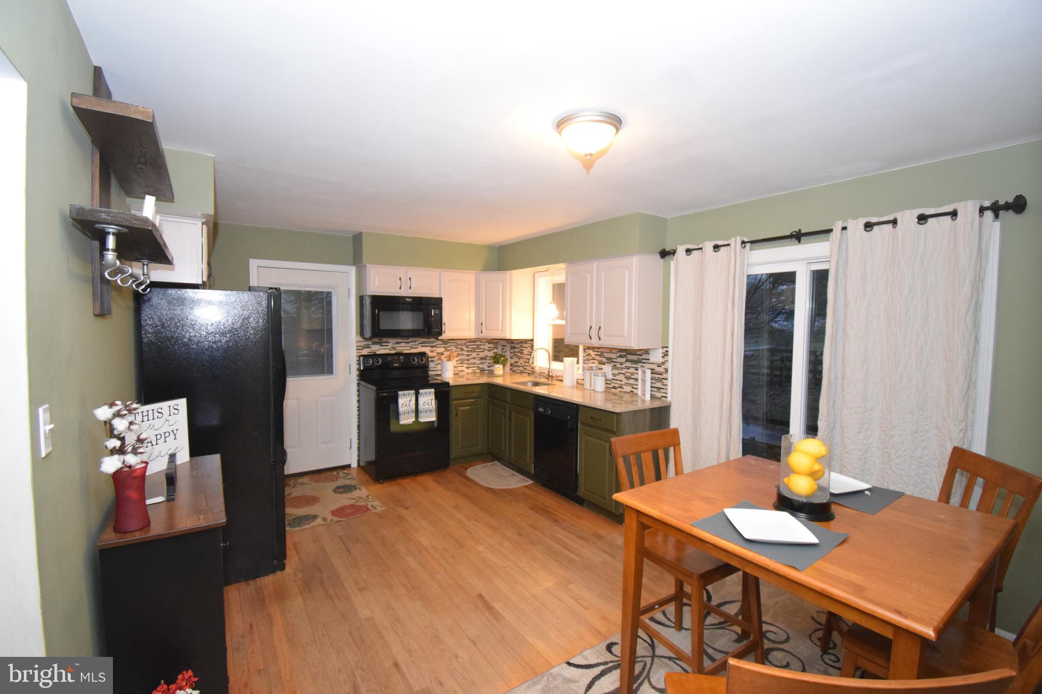 87 Half Mile Turn Rising Sun, MD 21911 - Photo 17 of 31 a kitchen with stainless steel appliances kitchen island granite countertop a refrigerator a stove a sink dishwasher with a dining table and chairs