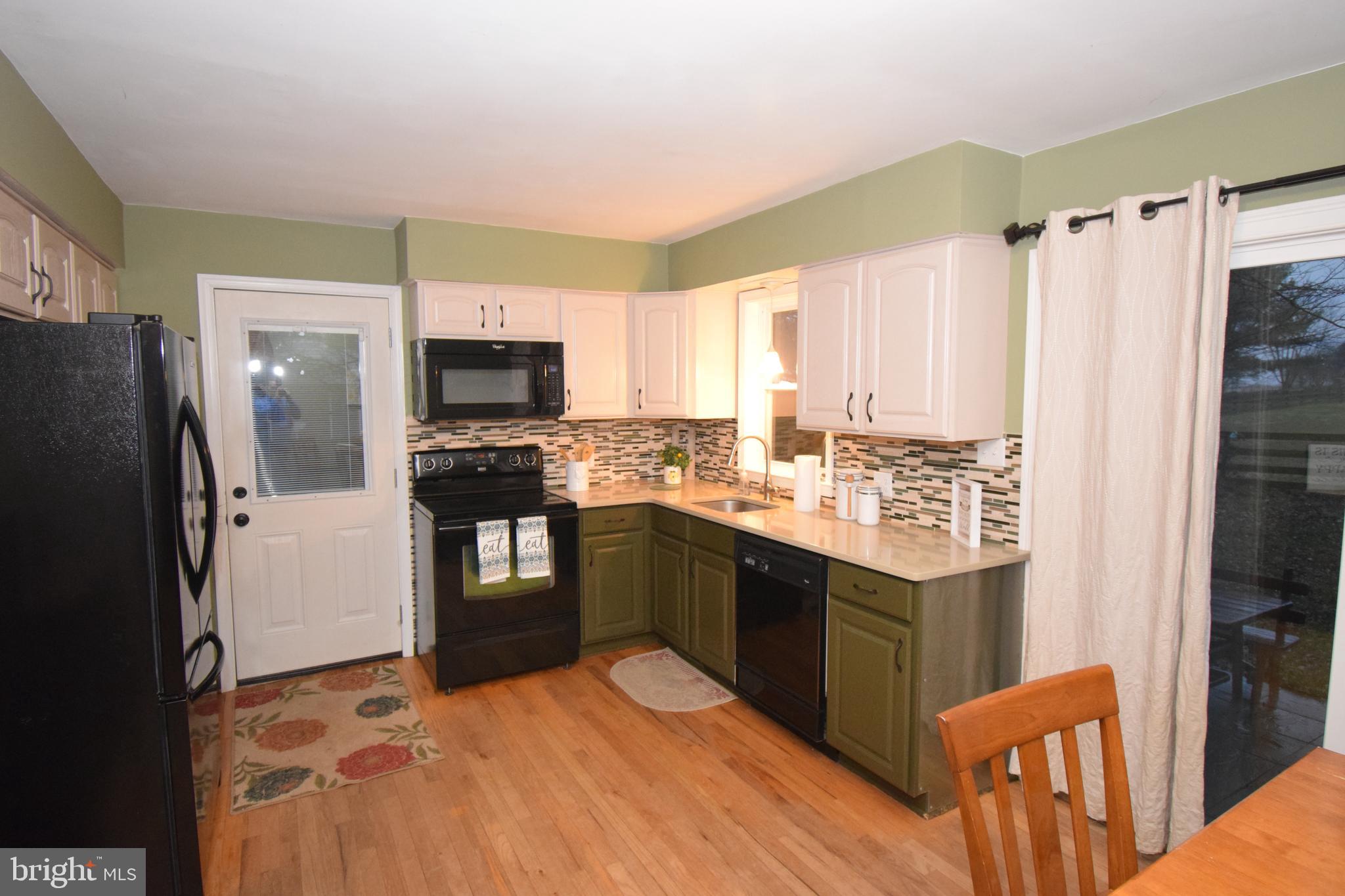 87 Half Mile Turn Rising Sun, MD 21911 - Photo 18 of 31 a kitchen with granite countertop a refrigerator and a stove top oven