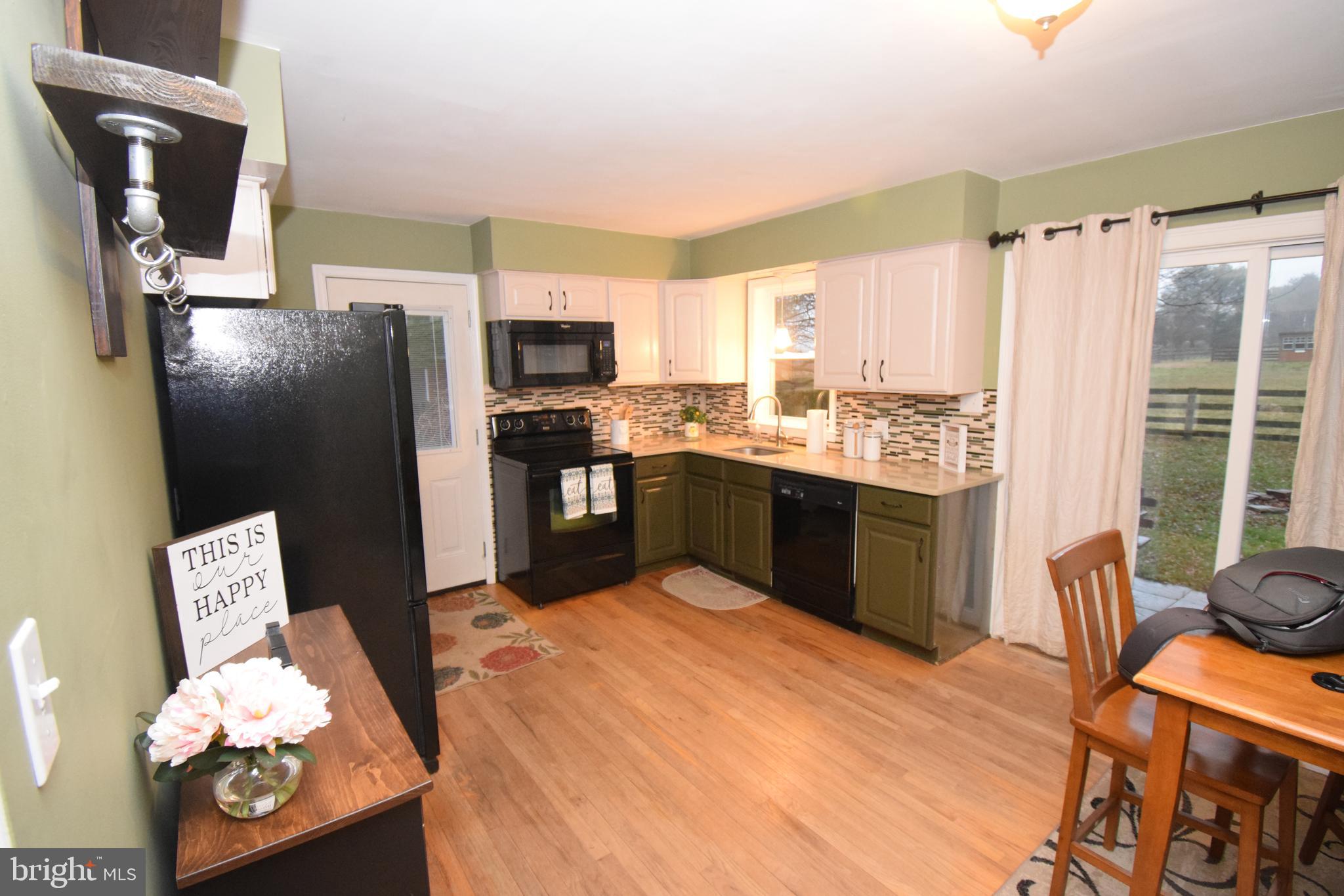 87 Half Mile Turn Rising Sun, MD 21911 - Photo 20 of 31 a kitchen with stainless steel appliances granite countertop a refrigerator a sink dishwasher a stove and a dining table with wooden floor