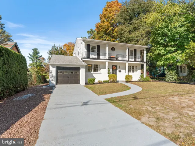 a front view of a house with a yard and trees