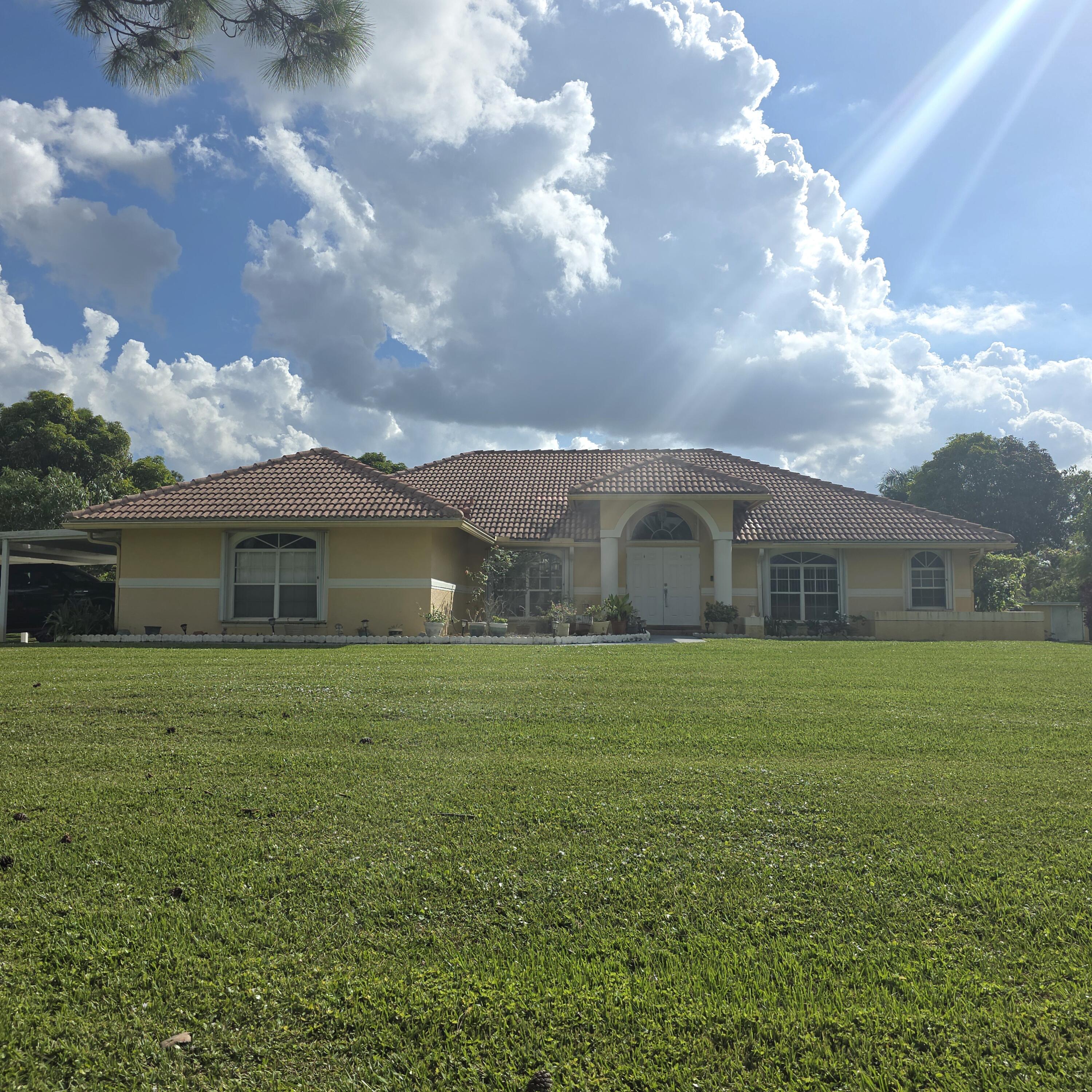 17930 79th Court North The Acreage, FL 33470 - Photo 1 of 1 a front view of house with yard and green space