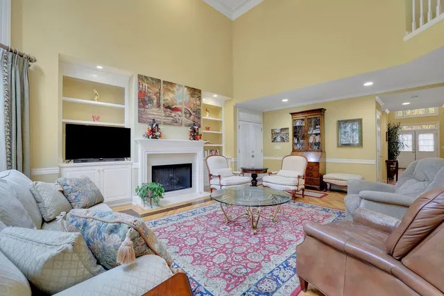 a kitchen with stainless steel appliances granite countertop a refrigerator a sink dishwasher a stove and a dining table with wooden floor