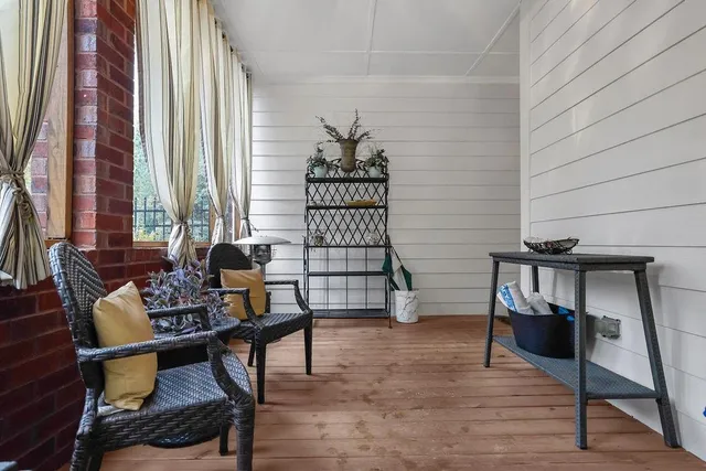 a front view of a house with garden and sitting area