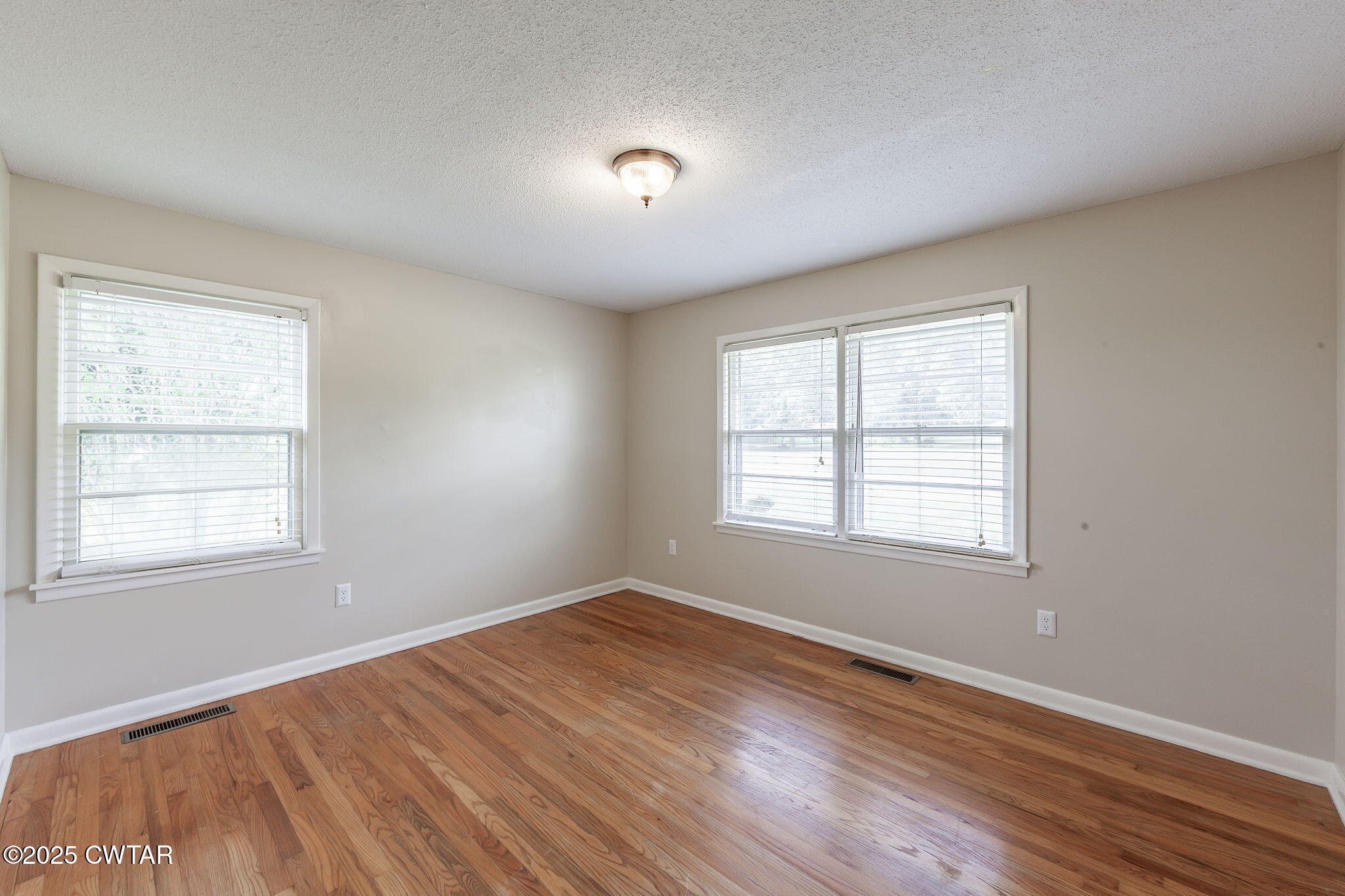 3810 Beech Bluff Road Jackson, TN 38301 - Photo 4 of 24 an empty room with wooden floor and windows