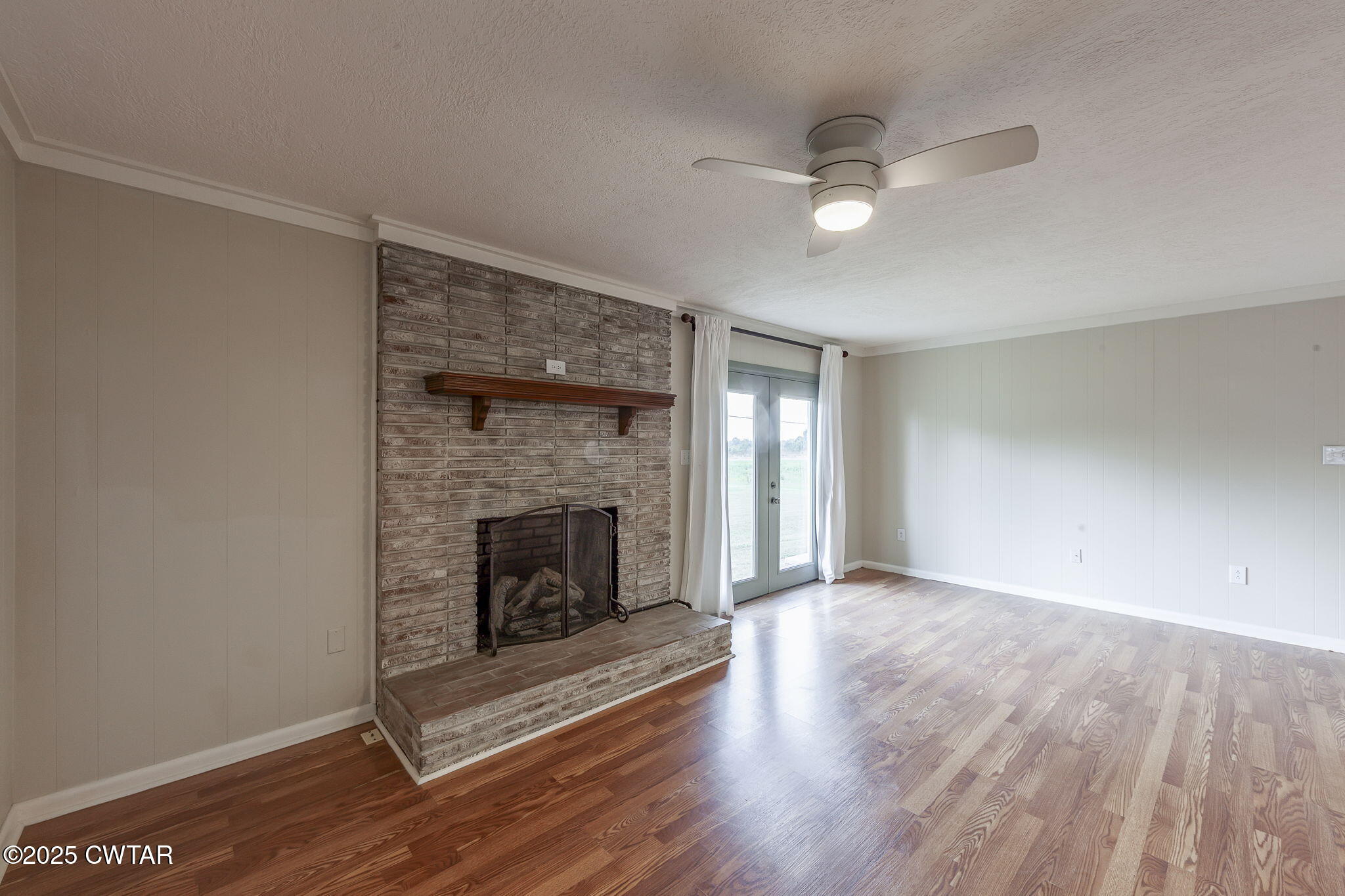 3810 Beech Bluff Road Jackson, TN 38301 - Photo 10 of 24 an empty room with wooden floor fireplace and windows