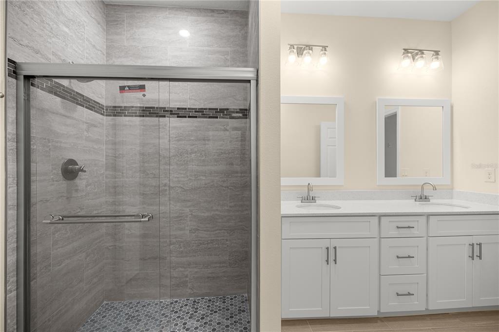 13745 Southwest 43rd Circle Ocala, FL 34473 - Photo 12 of 25 a bathroom with a granite countertop sink a mirror and shower