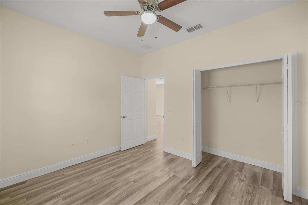 13745 Southwest 43rd Circle Ocala, FL 34473 - Photo 15 of 25 an empty room with wooden floor fan and windows