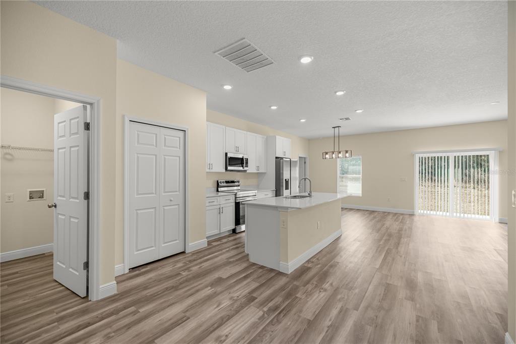 13745 Southwest 43rd Circle Ocala, FL 34473 - Photo 3 of 25 a view of kitchen with refrigerator microwave and wooden floor