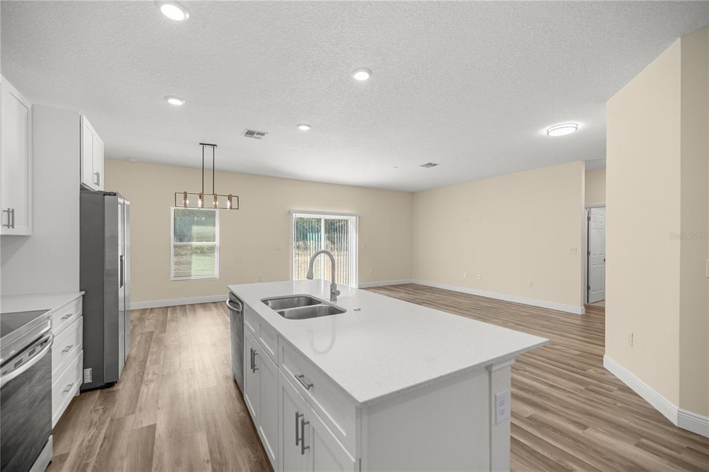 13745 Southwest 43rd Circle Ocala, FL 34473 - Photo 5 of 25 a kitchen with a stove a refrigerator and wooden floor