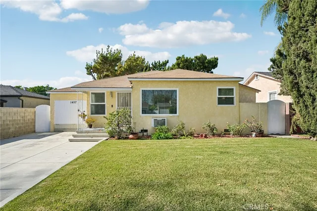 a front view of house with yard and trees in the background
