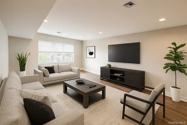 a living room with furniture a flat screen tv and a fireplace