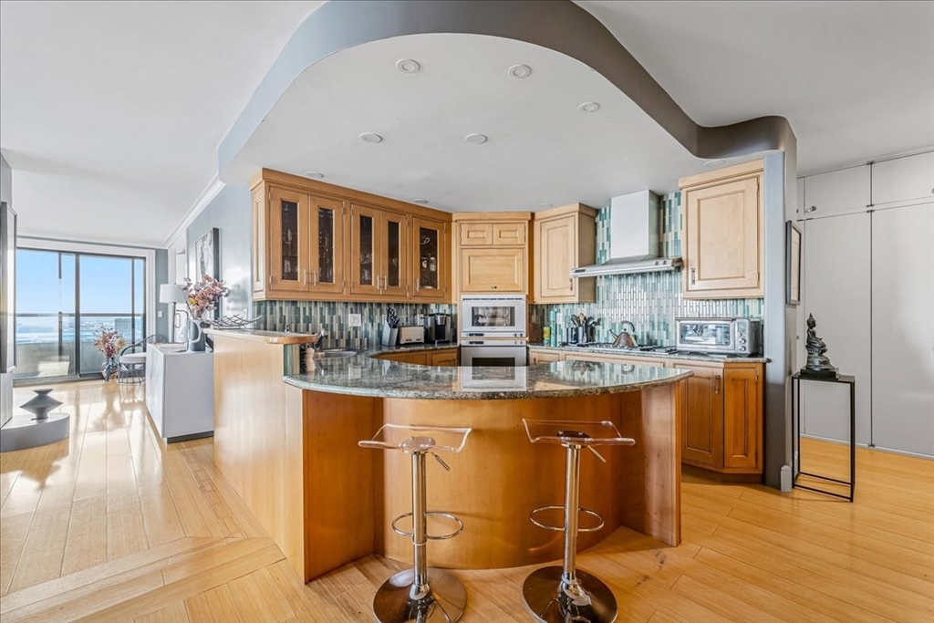 65 East India Row, Unit 26F Boston, MA 02110 - Photo 13 of 27 a kitchen with stainless steel appliances granite countertop a stove and cabinets
