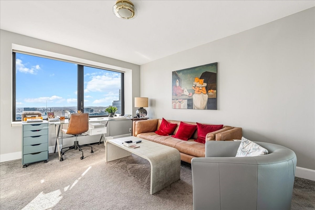 65 East India Row, Unit 26F Boston, MA 02110 - Photo 20 of 27 a living room with furniture and a floor to ceiling window