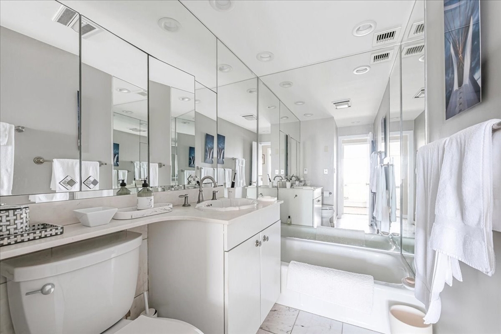 65 East India Row, Unit 26F Boston, MA 02110 - Photo 25 of 27 a bathroom with a double vanity sink a mirror and a bathtub