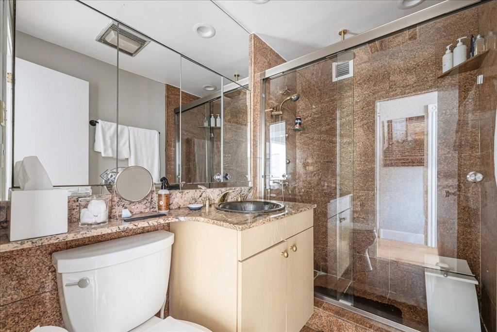 65 East India Row, Unit 26F Boston, MA 02110 - Photo 26 of 27 a bathroom with a sink toilet double vanity and shower