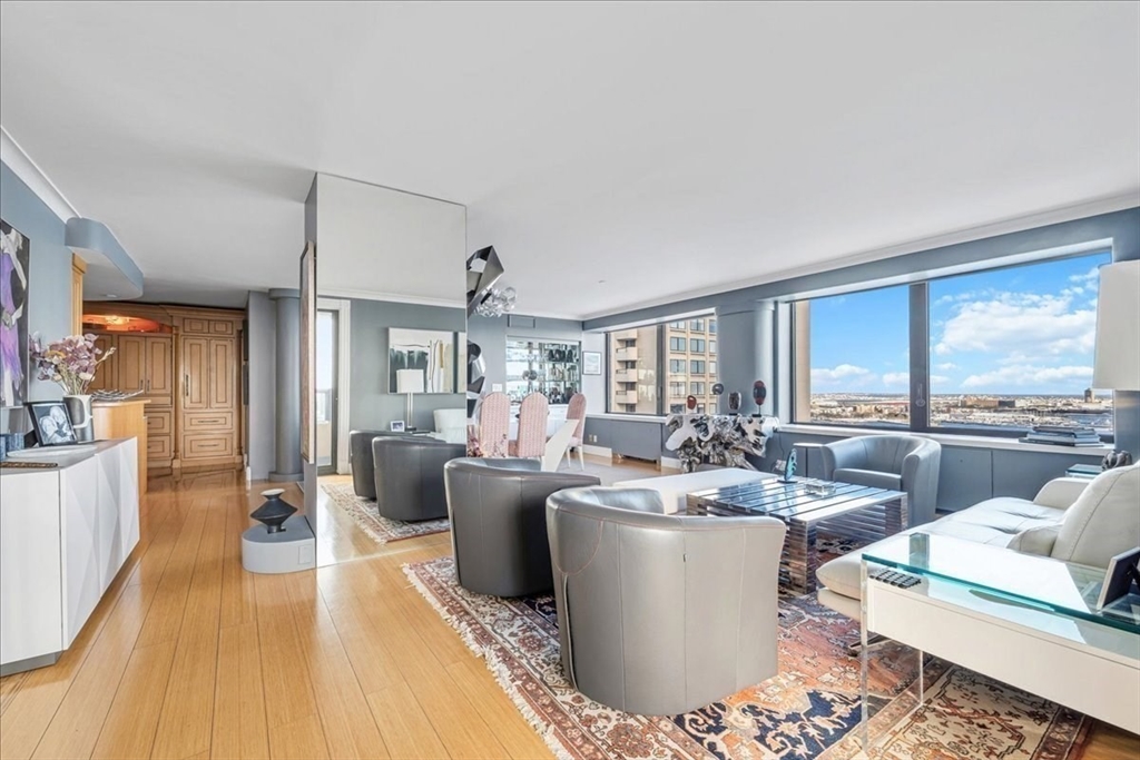 65 East India Row, Unit 26F Boston, MA 02110 - Photo 3 of 27 a living room with furniture a large window and wooden floor