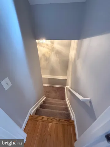 en empty room with a chandelier fan and wooden floor