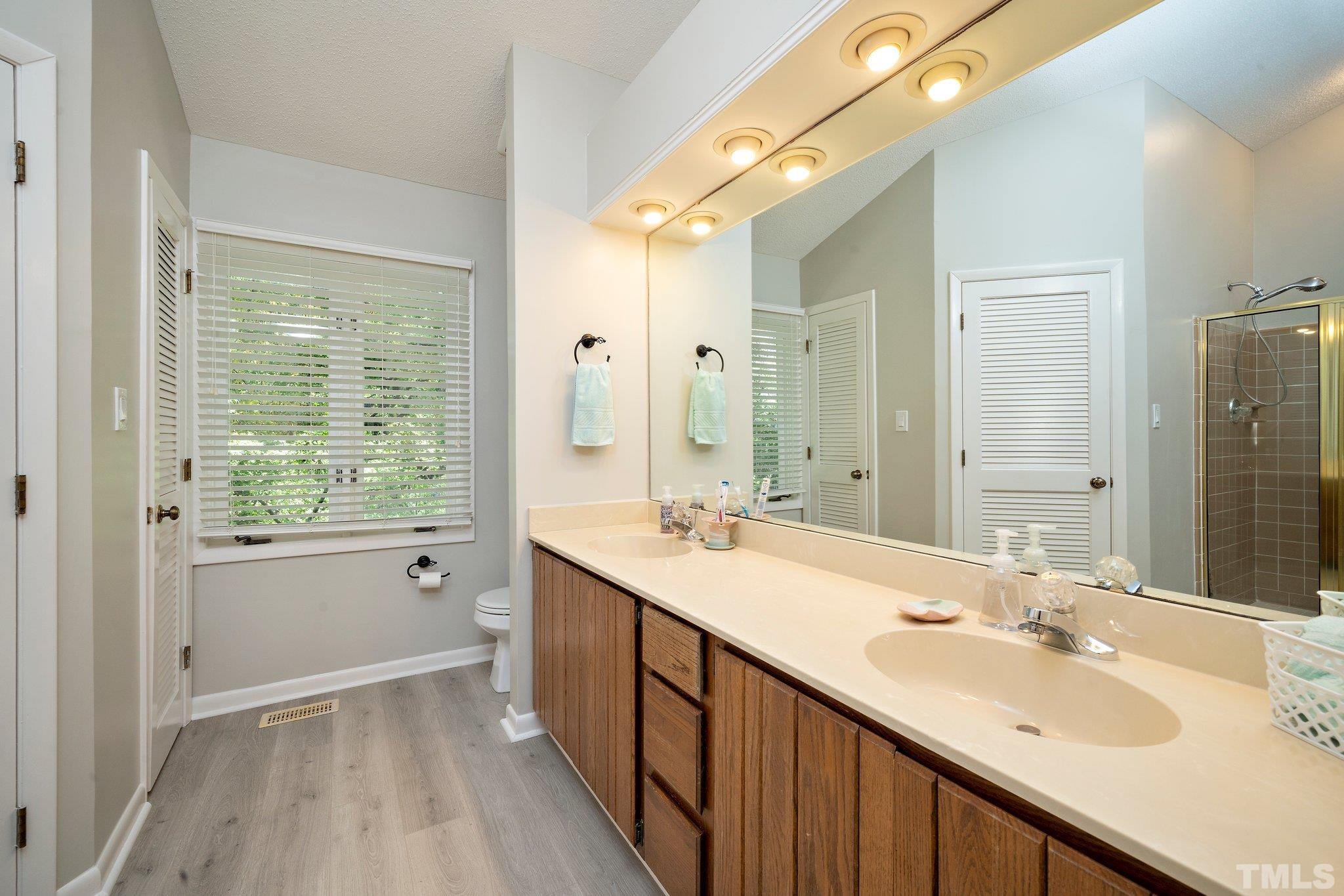4353 Southwind Drive Raleigh, NC 27613 - Photo 18 of 23 a bathroom with a sink double vanity granite tub shower and a mirror