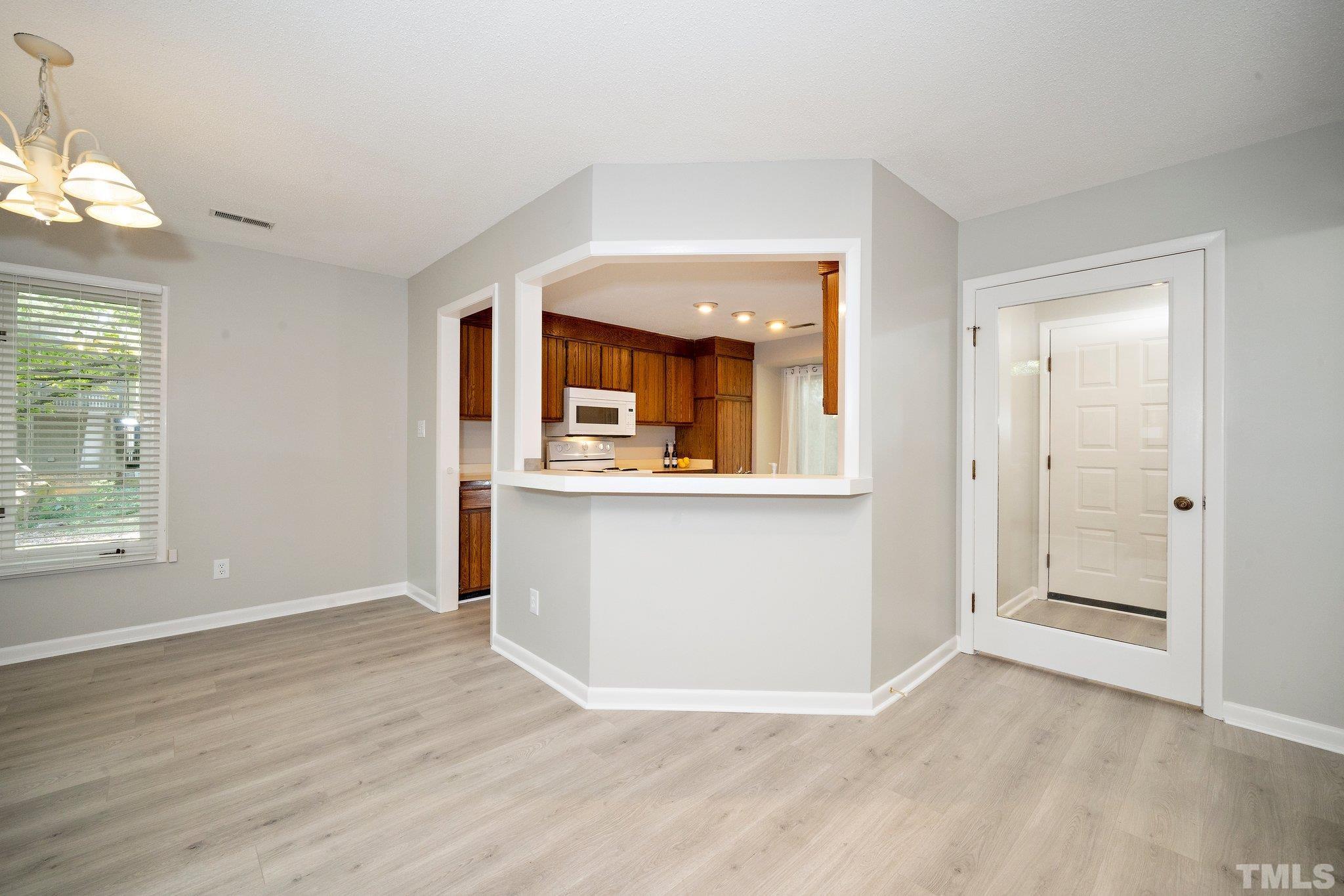 4353 Southwind Drive Raleigh, NC 27613 - Photo 6 of 23 an empty room with wooden floor and windows
