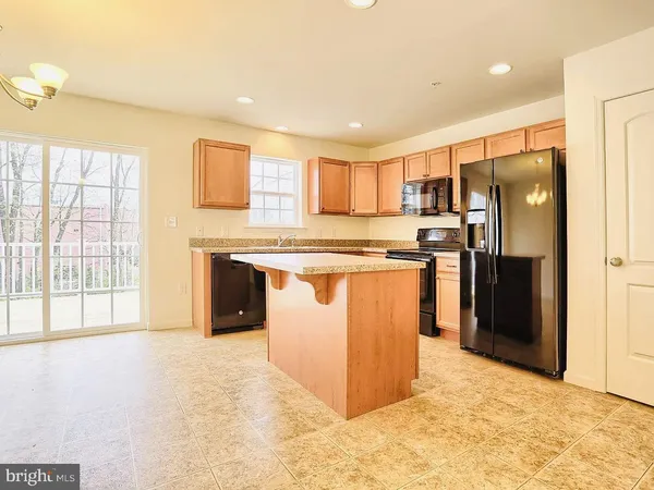 a kitchen with stainless steel appliances granite countertop a stove a refrigerator a sink a oven with white cabinets and wooden floor