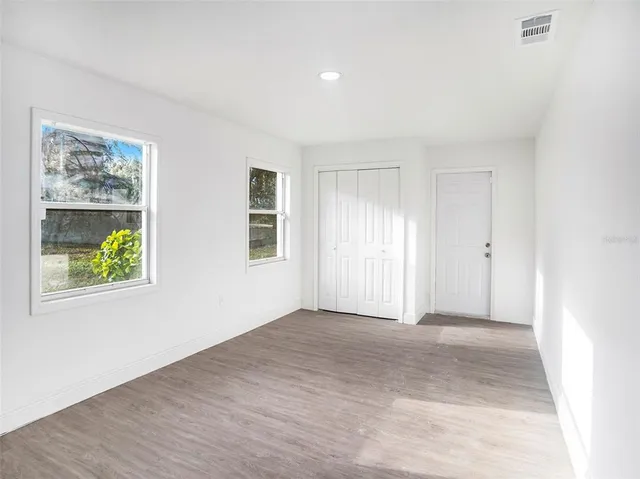 an empty room with windows and closet