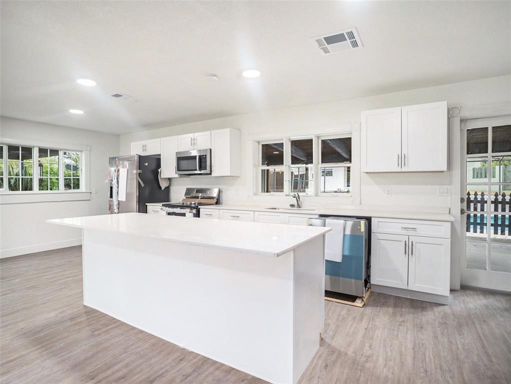 5136 Colbert Road Lakeland, FL 33812 - Photo 6 of 28 a kitchen with stainless steel appliances kitchen island granite countertop a stove a sink a refrigerator and white cabinets with wooden floor
