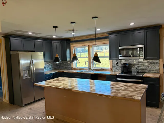 a kitchen with stainless steel appliances granite countertop a sink a stove and a refrigerator