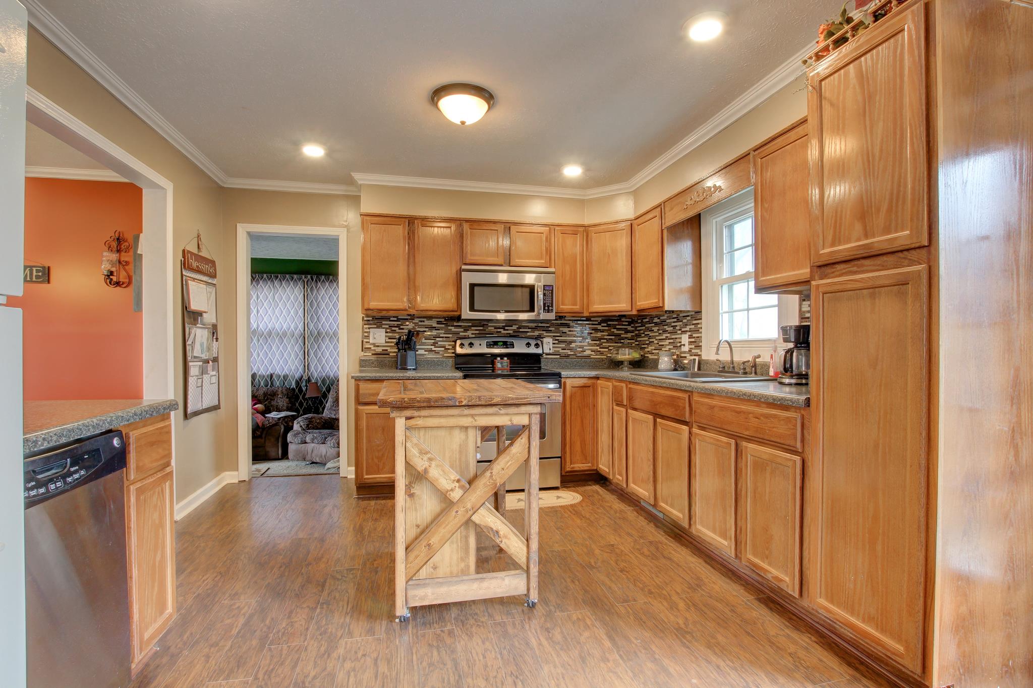 35 Locust Road Erin, TN 37061 - Photo 6 of 20 a kitchen with stainless steel appliances granite countertop a stove a sink a refrigerator white cabinets and wooden floor
