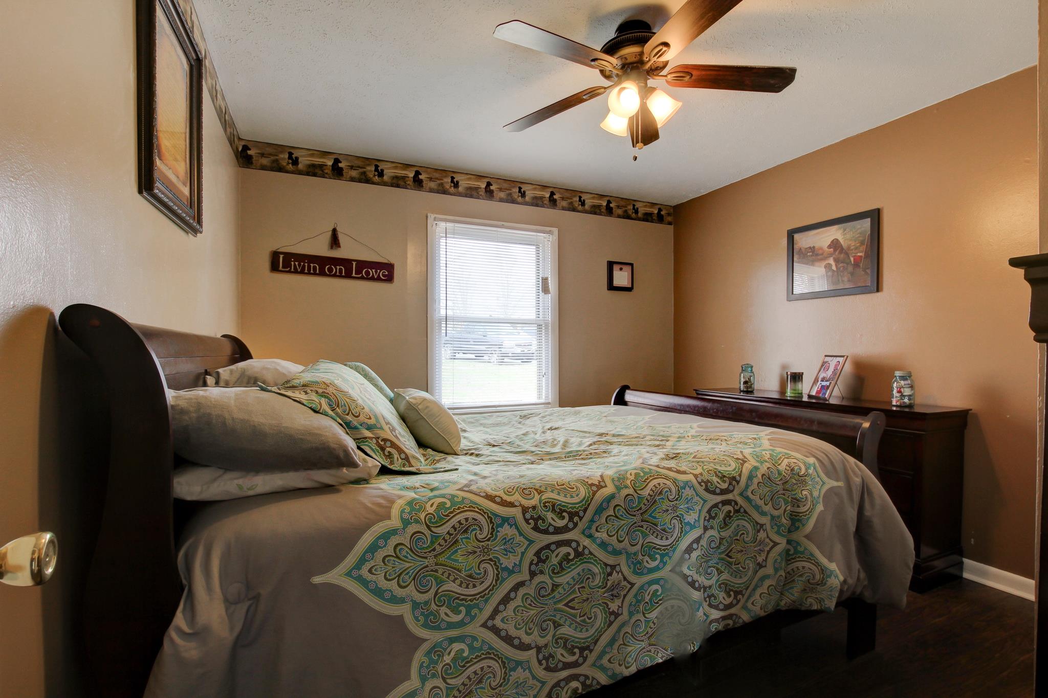 35 Locust Road Erin, TN 37061 - Photo 9 of 20 a bedroom with a bed and a chandelier